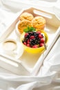 Wooden tray with tasty breakfast on bed. Espresso, banana muffins, cottage cheese with blueberry and raspberry Royalty Free Stock Photo