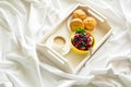 Wooden tray with tasty breakfast on bed. Espresso, banana muffins, cottage cheese with blueberry and raspberry Royalty Free Stock Photo