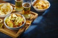 On a wooden tray, two glasses of light beer, potato chips, onion rings. A classic set of sports fans. Watching sports programs on Royalty Free Stock Photo