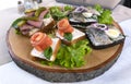 Wooden tray with various sandwiches with salmon, marinated herring and thinly sliced cold beef with green lettuce