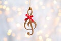 Treble clef against blurred lights. Christmas music Royalty Free Stock Photo