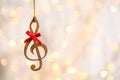 Wooden treble clef against blurred lights. Christmas music Royalty Free Stock Photo