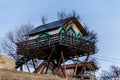 A wooden treehouse on the background of a pure blue sky