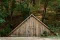 wooden triangular hut in the forest. An ancient building in a dark forest. Abandoned house without windows. shed without windows Royalty Free Stock Photo