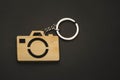 Wooden trinket in the form of a camera on a black background. keychain