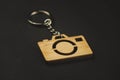 Wooden trinket in the form of a camera on a black background. keychain