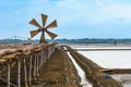 Wooden turbine at salt pan using for press seawater up to field with blue sky background in summer time of Thailand,South East Royalty Free Stock Photo