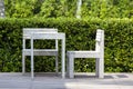 Wooden two chairs and white table in empty cafe of a tropical garden on the beach, Thailand. Close up Royalty Free Stock Photo