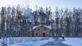 A wooden two-storey house stands in the snow.