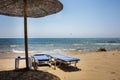 Wooden Umbrella Screening the Sunlight and Heat. Folded and Unfolded Adjustable Beach Recliner Facing the Ocean. Fine