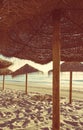 Wooden umbrellas in empty beach at sunset Royalty Free Stock Photo