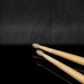 Wooden used drumsticks on a blackboard with reflections