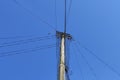 Wooden utility pole made from tree trunk, power cables against blue sky Royalty Free Stock Photo
