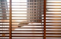 Wooden Venetian blinds. Blackout curtain between bathroom and bedroom in hotel with back view of woman sleep under white blanket