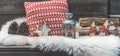 Wooden veranda with lambskin, red and white Christmas pillows, lantern and logs