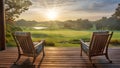 wooden veranda at a resort with two armchairs and tranquil sunrise view over the golf course