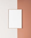 Wooden vertical frame mock up. Poster frame on orange and white wall.