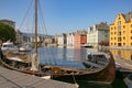 Wooden viking boat moored at the pier in the city centre of Alesund, Norway. Royalty Free Stock Photo
