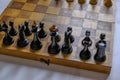 Wooden vintage black chess pieces on a chessboard close-up. Playing chess. Strategy, planning concept Royalty Free Stock Photo
