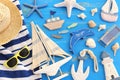 Wooden vintage boat, dolphin, hoat`towel and sea shells over blue background Royalty Free Stock Photo