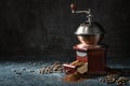 Wooden vintage coffee grinder, roasted beans and ground coffee on a dark rustic background with copy space, selected focus Royalty Free Stock Photo