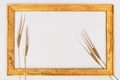 Wooden vintage golden frame made of wood with spikelets of rye. Concept of rich harvest. Autumn creative still life. Royalty Free Stock Photo
