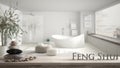 Wooden vintage table shelf with pebble balance and 3d letters making the word feng shui over blurred modern classic bathroom with