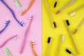 Wooden vs plastic toothbrushes on a yellow and pink background. Flat lay wood against plastic, eco and zero waste