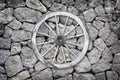 Wooden wagon wheel on a stone back ground. Royalty Free Stock Photo