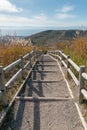 Wooden walking path leading to mountain slope Royalty Free Stock Photo