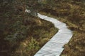 Wooden walkpath with green grass in forest. Empty wooden road in perspective. Rural old pathway. Place for text or advertising