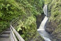 Wooden walkway alongside a waterfal