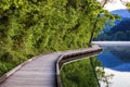 Wooden walkway around the lake Bled with mountains and houses on the background. Beautiful Slovenian Nature. Bled, Slovenia, Royalty Free Stock Photo