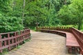 Wooden walkway with benches and fence in the forest Royalty Free Stock Photo