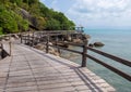 Wooden walkway or bridge by the sea. Old wooden walkway with a gazebo on the shore of the tropical sea Royalty Free Stock Photo