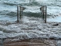 Wooden walkway going into the sea flooded. Tide, storm