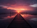 a wooden walkway leads into the ocean at sunset