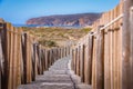 wooden walkway next to the ocean with rocky beach in background Royalty Free Stock Photo