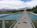 Wooden walkway over blue river and beautiful mountain background Royalty Free Stock Photo