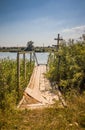 Wooden walkway on the pond. A wooden deck on a pond. A lake and an old wooden bridge Royalty Free Stock Photo