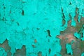 Wooden wall with peeling turquoise old oil paint. Natural background