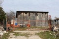 Wooden warehouse building behind rusted metal fence doors