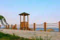 A wooden watchtower on the embankment for lifeguards to watch swimming tourists having a rest. Background