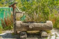 Wooden water fountain in the mountains of the alpine valleys Royalty Free Stock Photo