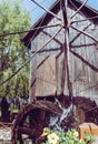 Wooden Water mill with flowers in a lake