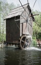 Wooden Water mill with flowers in a lake