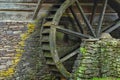 Wooden water paddle wheel and mossy stones on the side of a old Royalty Free Stock Photo