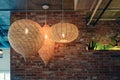 Wooden weave lamp hanging on ceiling and brick wall