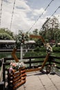Wooden wedding arch for the ceremony with flowers and decor near the water in the park Royalty Free Stock Photo