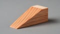 Wooden wedge with a right triangular prism shape on a flat grey surface Royalty Free Stock Photo